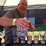 David "Yogi" Dean, festival volunteer, pours beer for Bridge Brew Works at the Rails & Ales Craft Beer Festival